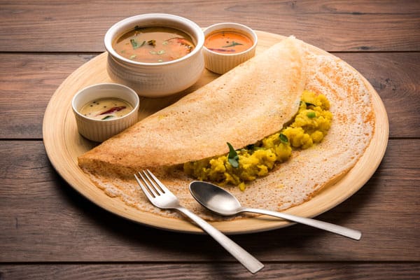 A crisp golden masala dosa served with chutney and sambar